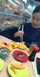 girl eating at a running sushi